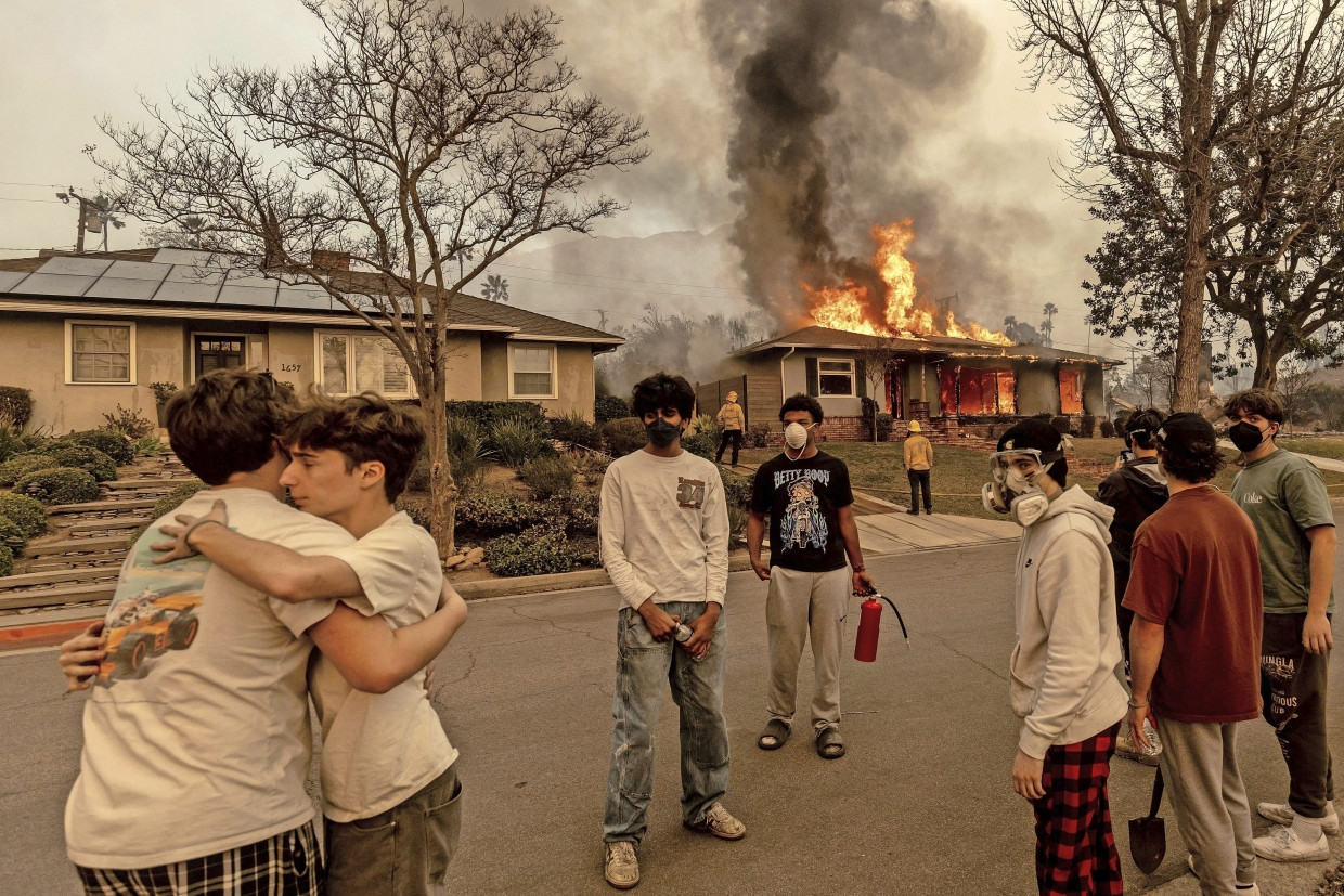 In Altadena: Anwohner umarmen sich zum Trost, während im Hintergrund ein Haus niederbrennt; ein Feuerwehrmann kämpft gegen das Eaton-Feuer an.