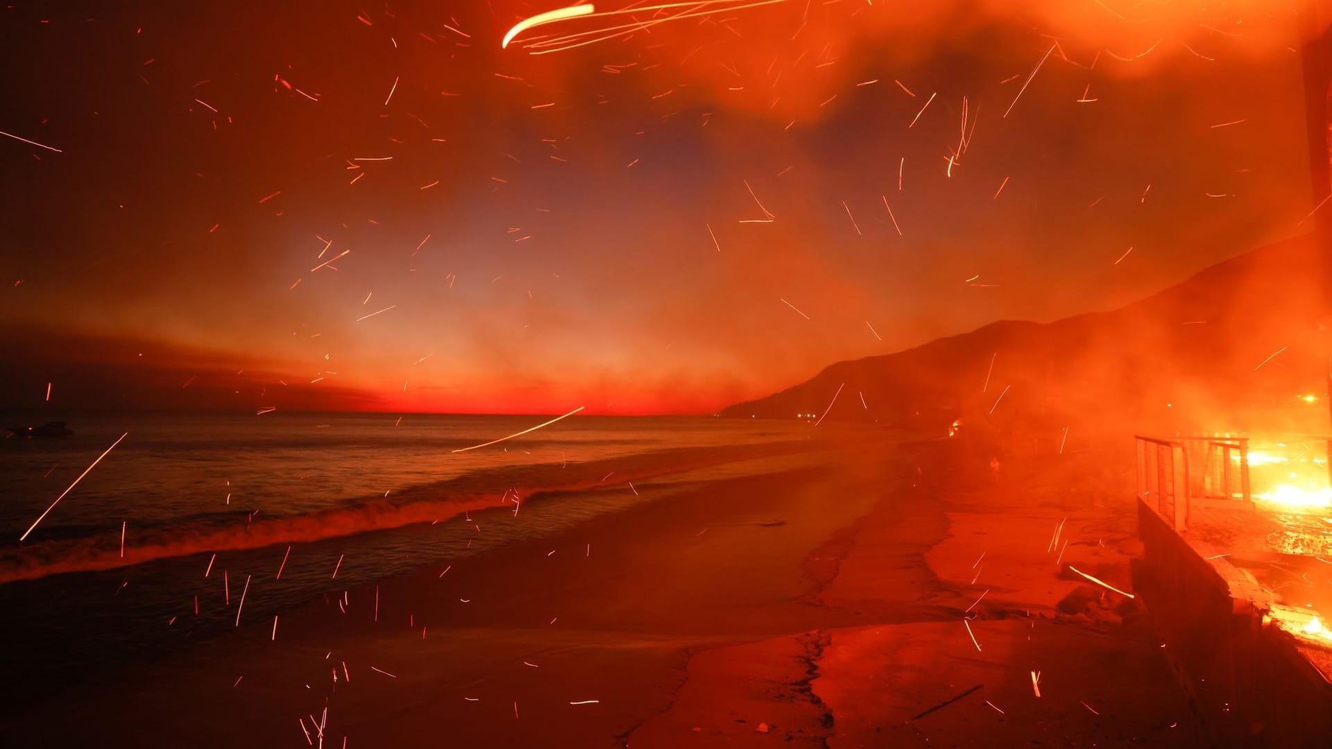 USA, Malibu: Das Palisades-Feuer brennt auf einem Grundstück am Strand.