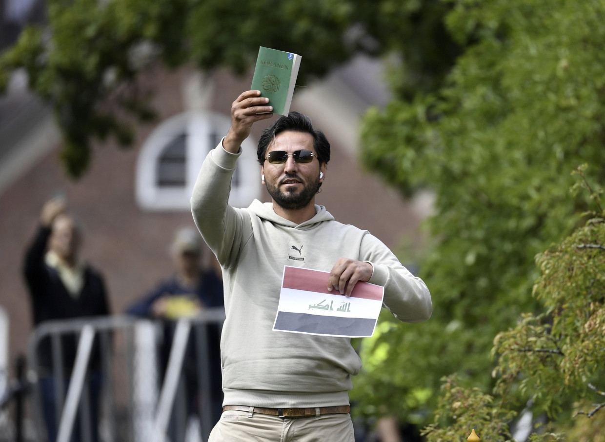 Salwan Momika hält im Juli 2023 in Stockholm eine Kopie des Korans hoch.