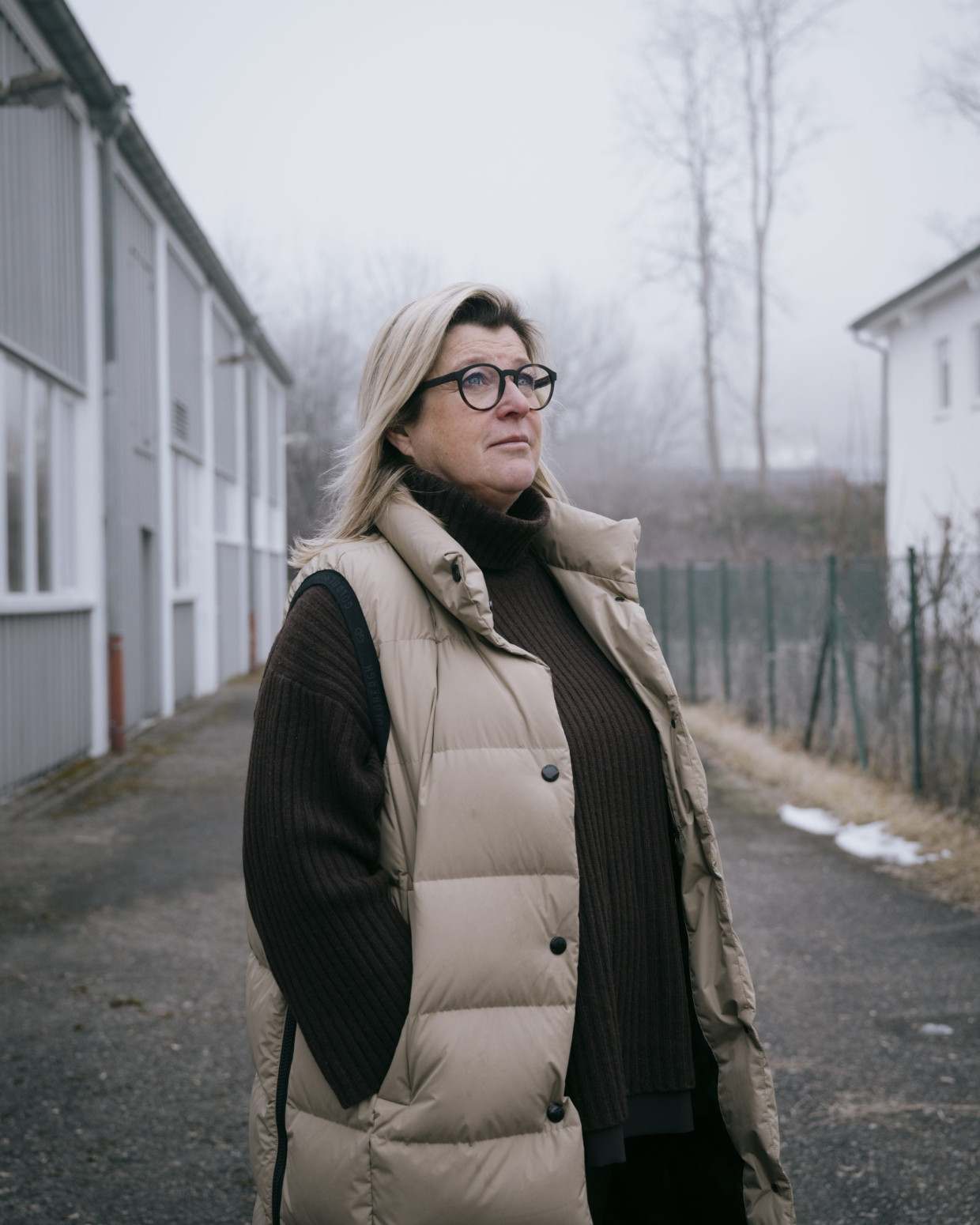 Heike Bachert steht auf ihrem Grundstück, das an das Gebäude grenzt in dem die Unterkunft entstehen soll.