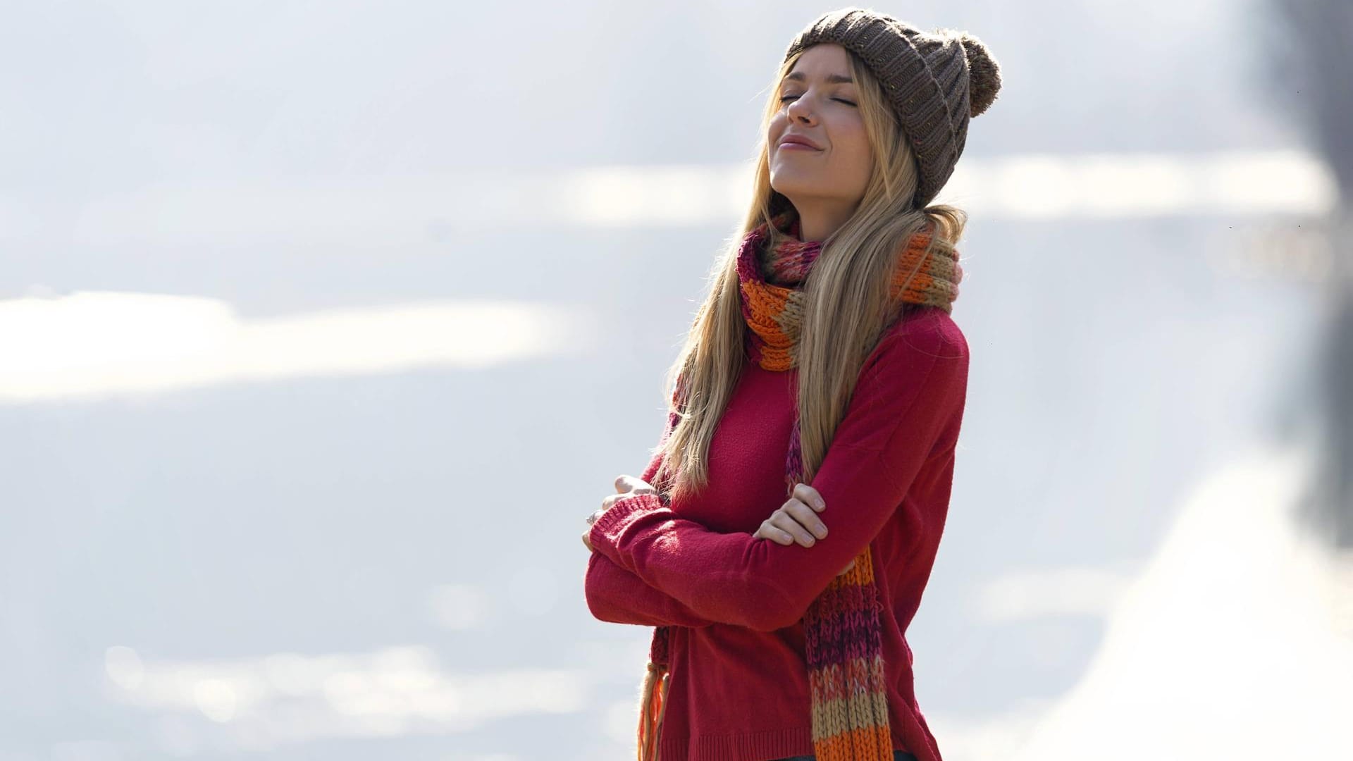 Frau in der Natur: Schal und Mütze bieten ausreichend Schutz vor der Kälte und sind ein Muss im Winter.