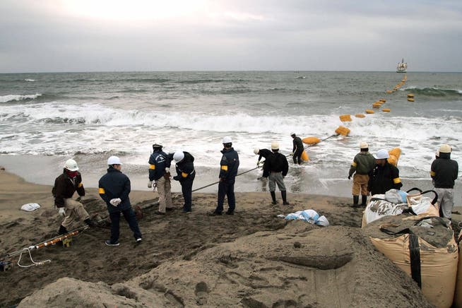 Arbeiter ziehen 2012 in Minamiboso, Präfektur Chiba, Japan ein Unterwasser-Glasfaserkabel von einem vor der Küste verankerten Schiff zu einem Strand. Das Kabel verbindet Japan und Singapur.