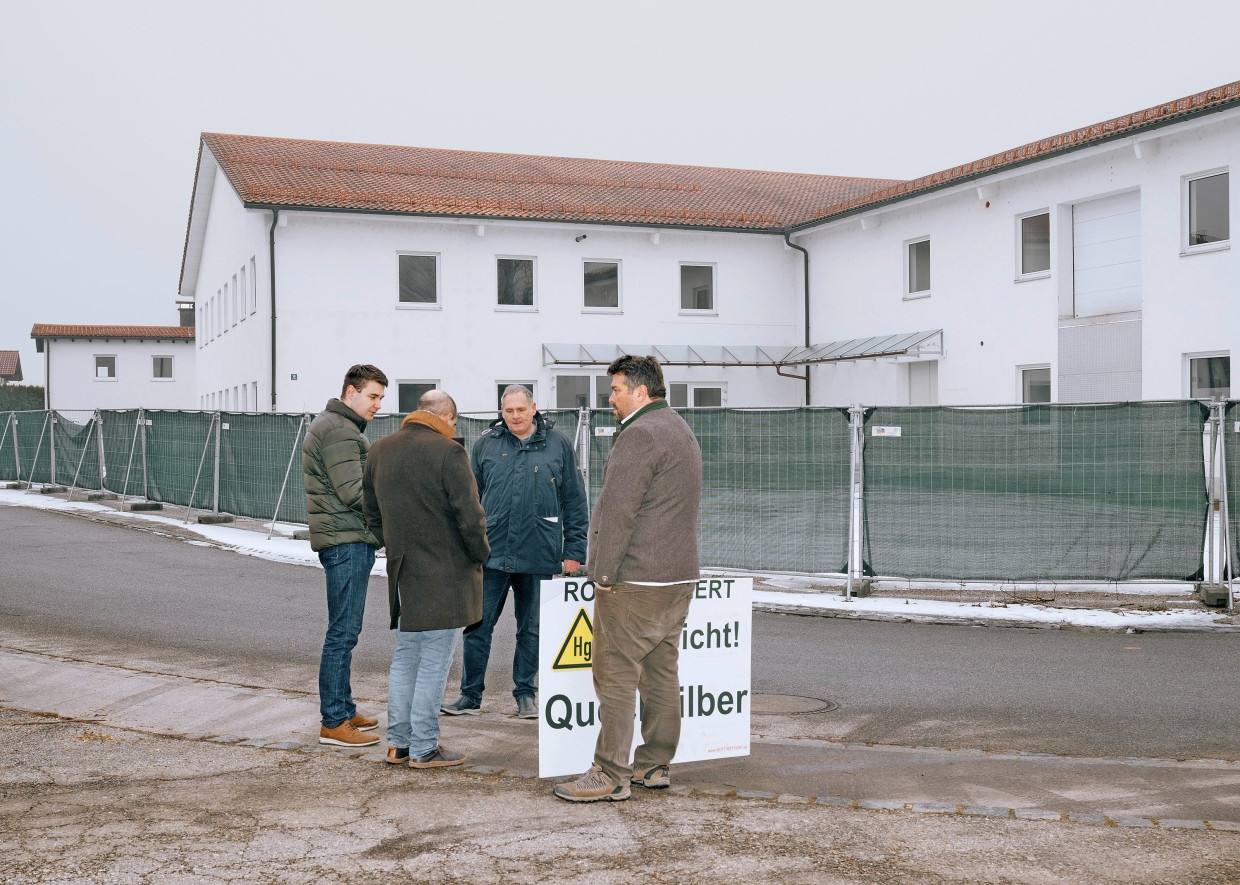 Mitglieder der Bürgerinitiative und der Bürgermeister stehen gemeinsam vor der Gewerbehalle, in dem eine Flüchtlingsunterkunft entstehen soll