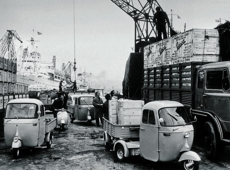 Schiffe werden im Hafen von Genua entladen. Die Ape mit fünf Rädern kam 1961.