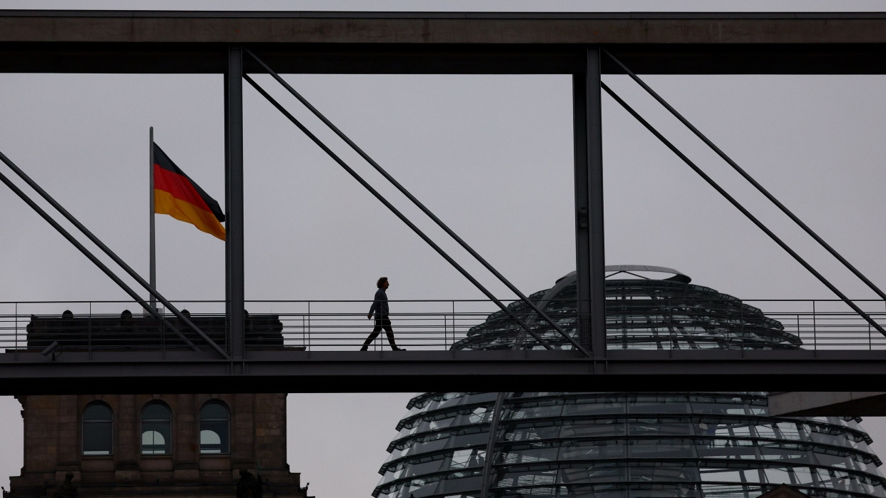 Ein Fußgänger geht über eine Brücke zwischen Gebäuden des Bundestags in Berlin.