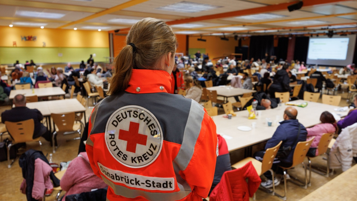 Bombenverdacht in Osnabrück: Eine Mitarbeiterin von Deutsches Rotes Kreuz steht im Evakuierungszentrum der Stadt in einer Schule.