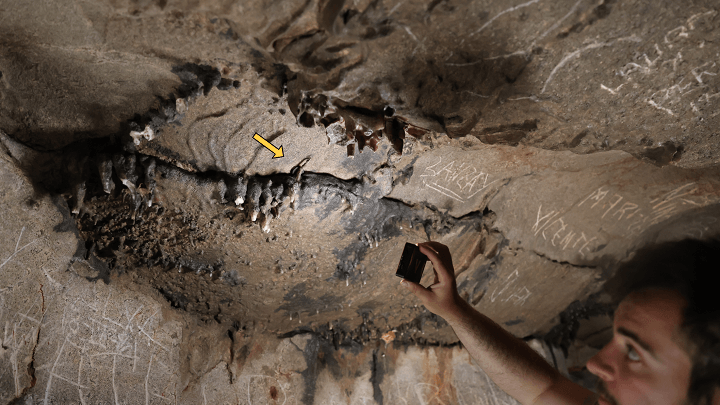 Der Forscher Xabier Garín Artázcoz weist auf die genaue Stelle der Höhle hin: Hier wurde eine römische Münze aus der Zeit des Kaisers Claudius entdeckt