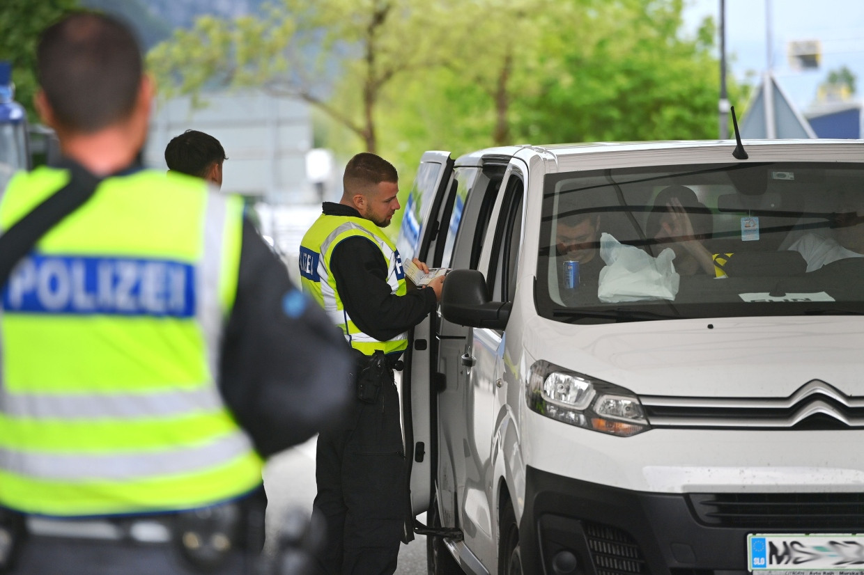Polizisten kontrollieren die Insassen eines weißen Lieferwagens am Grenzübergang Kiefersfelden