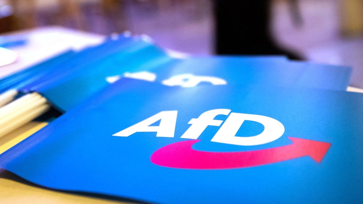 Fähnchen mit dem Logo der AfD liegen auf einem Tisch.