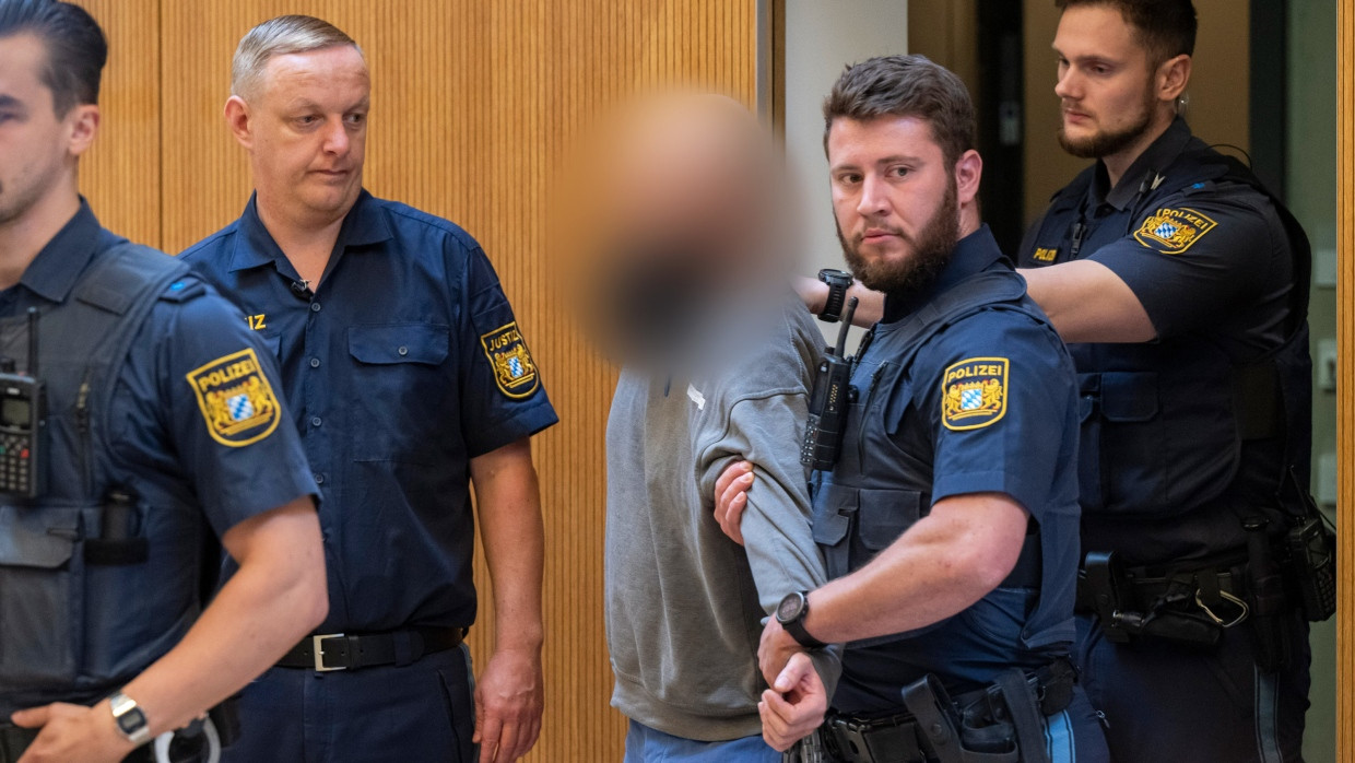 Ein Angeklagter wird zu Beginn des Prozesses gegen ein deutsch-russisches Trio wegen Geheimdiensttätigkeit für Russland in den Gerichtssaal in München am Dienstag geführt.
