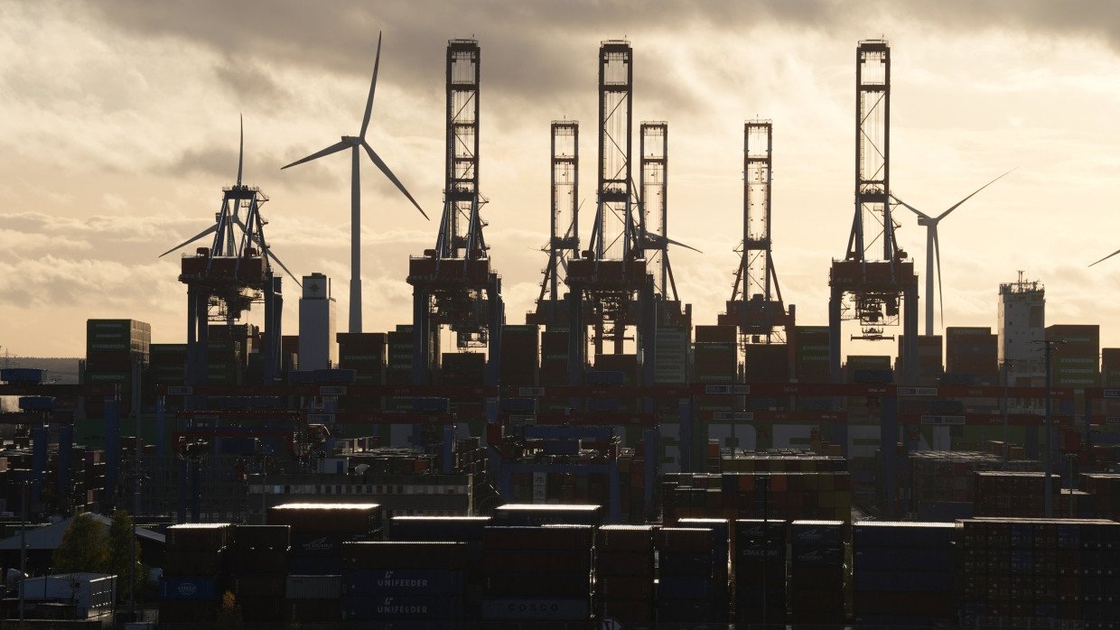 Die Sonne scheint durch dicke Wolken über dem Container Terminal Burchardkai im Hamburger Hafen.