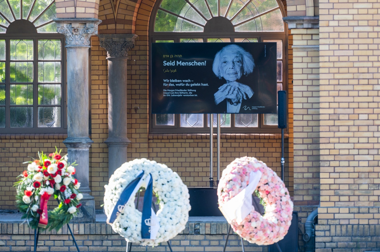 Am Tag der Beisetzung der Holocaust-Überlebenden Margot Friedländer stehen Kränze und ein Bild von ihr auf dem Jüdischen Friedhof Weißensee.
