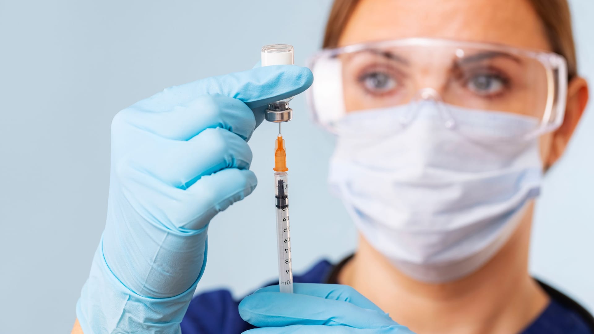Doctor fills syringe with medicine from vial. Vaccination and immunization Doctor fills syringe with medicine from vial. Vaccination and immunization