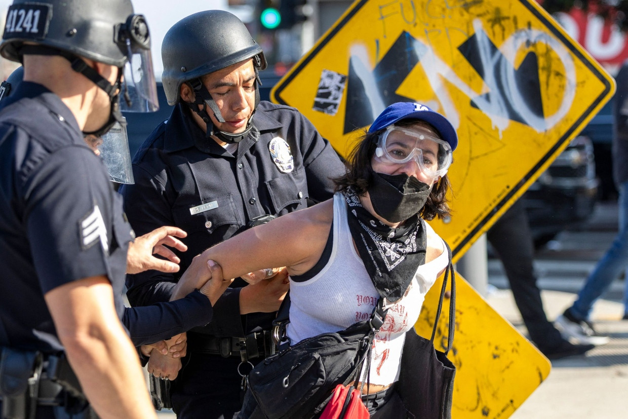 Eine protestierende Frau wird festgenommen.