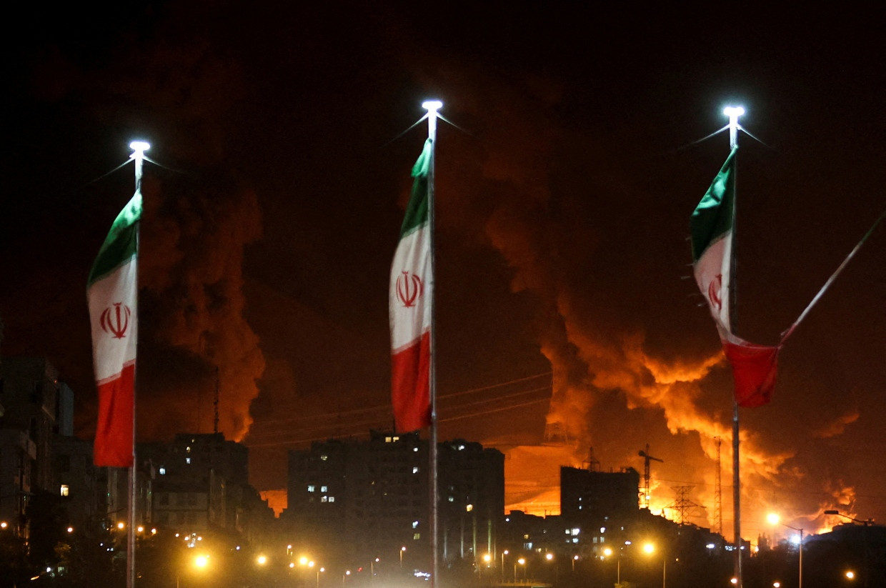 Iranische Flaggen vor einem Öl-Depot nahe Teheran, das von der israelischen Luftwaffe angegriffen wurde