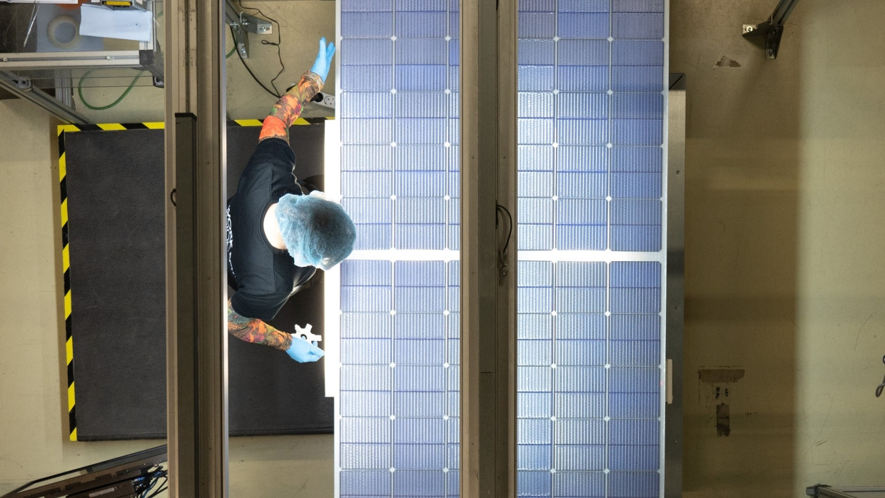 In Freiburg: Eine Mitarbeiterin von Meyer Burger steht bei der Qualitätskontrolle an einer Produktionslinie für Solarmodule.