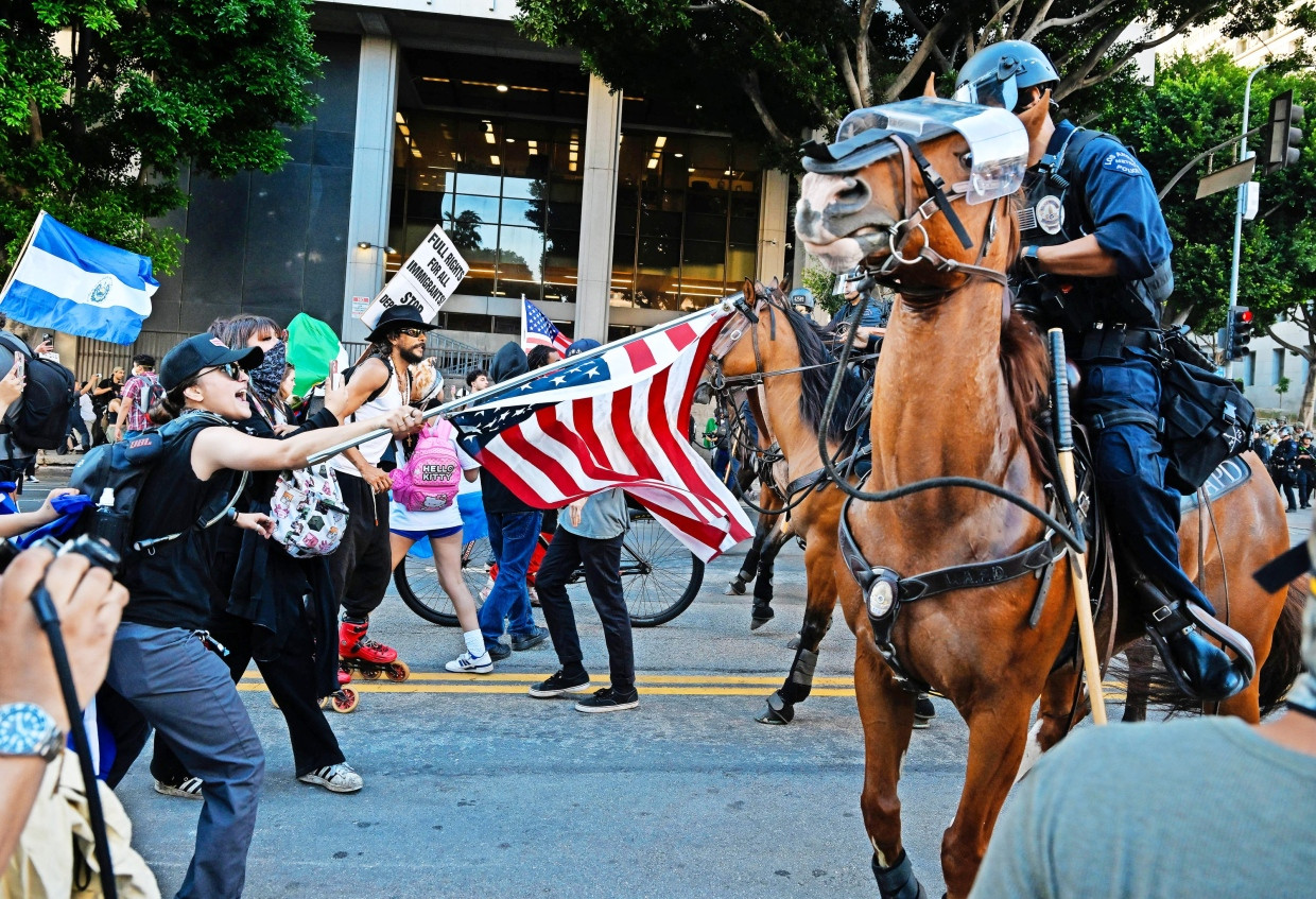 Reiterpolizisten stehen vor der Stadtverwaltung in Los Angeles Demonstranten gegenüber.