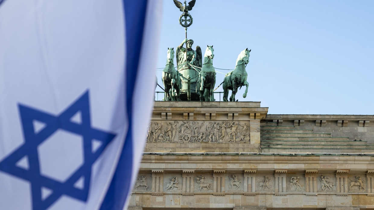 Teilnehmer des Jüdischen Jugendkongresses schwenken vor dem Brandenburger Tor im Dezember 2024 eine Israel-Flagge.