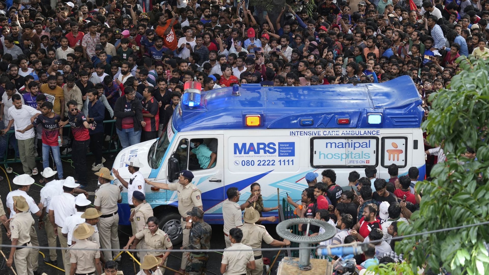 Großeinsatz: Ein Krankenwagen bahnt sich den Weg durch die Menschenmassen in Bengaluru. Großeinsatz: Ein Krankenwagen bahnt sich den Weg durch die Menschenmassen in Bengaluru.