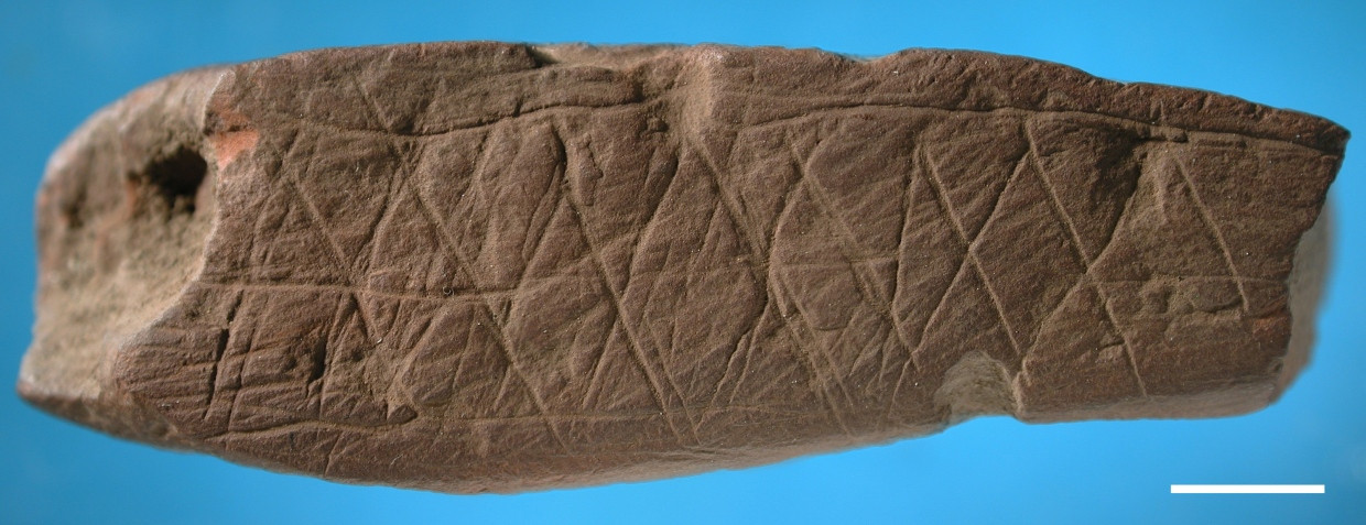 Frühste Ornamente: Die Verzierungen auf diesem sieben Zentimeter langen Stück Ocker aus der Blombos-Höhle in Südafrika ritzten Angehörigen des Homo sapiens vor rund 70.000 Jahren.