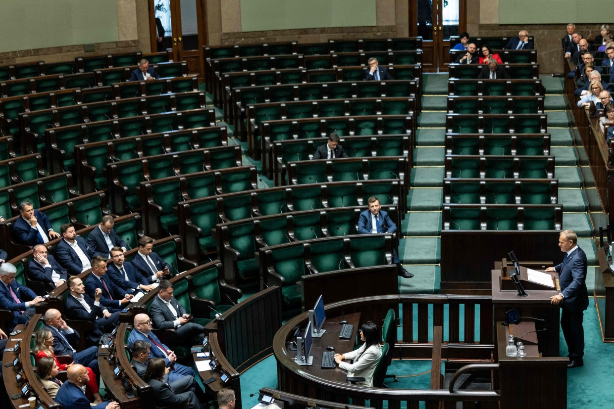Polens Ministerpräsident Donald Tusk spricht vor der Vertrauensabstimmung im Parlament. Die Sitze der Abgeordneten der Oppositionspartei Recht und Gerechtigkeit (PiS) sind leer.