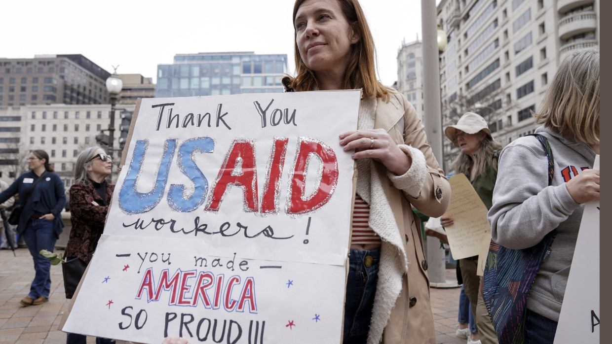 Ein Frau hält ein Schild zur Unterstützung der Mitarbeiter der US-Behörde in die Höhe, während die Ende Februar ihre persönlichen Gegenstände aus der Zentrale holen.