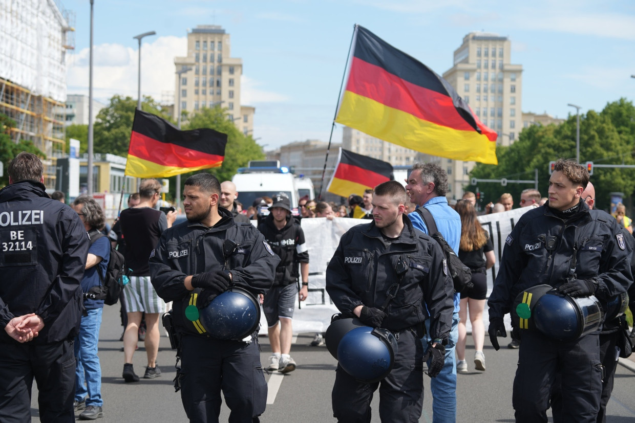 Teilnehmer einer Demonstration aus dem rechten Spektrum gehen in Berlin am 1. Juni 2025 mit Deutschland-Fahnen über die Straße.