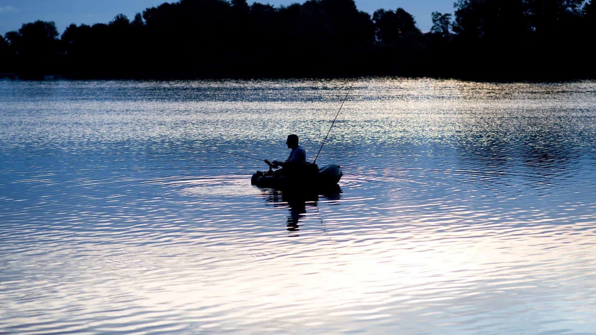 Ein Angler kurz nach Sonnenaufgang Ein Angler kurz nach Sonnenaufgang