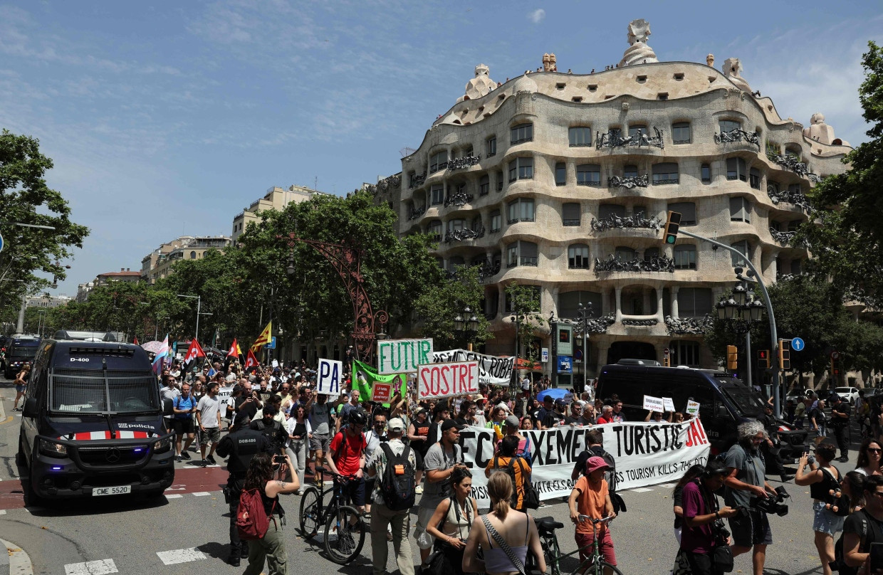 Demonstranten marschieren während einer Demonstration gegen den Massentourismus in Barcelona an der Sehenswürdigkeit La Pedrera vorbei.