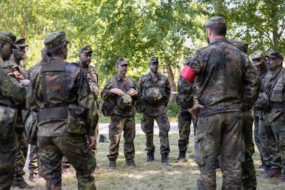 Im Gelände: Bei der Ausbildung von Ungedienten zur Reserve steht auch Tarnung auf dem Programm. Hochkonzentriert hören die Rekruten ihrem Ausbilder zu.