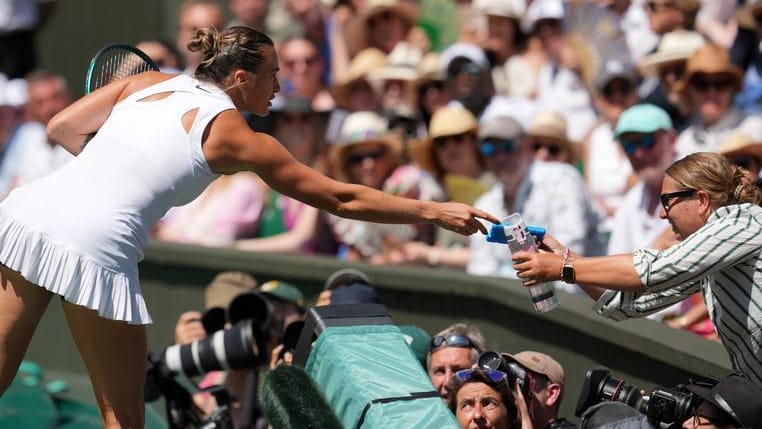 Hilfe vom Tennis-Superstar: Aryna Sabalenka reicht eine Wasserflasche ins Publikum. Hilfe vom Tennis-Superstar: Aryna Sabalenka reicht eine Wasserflasche ins Publikum.