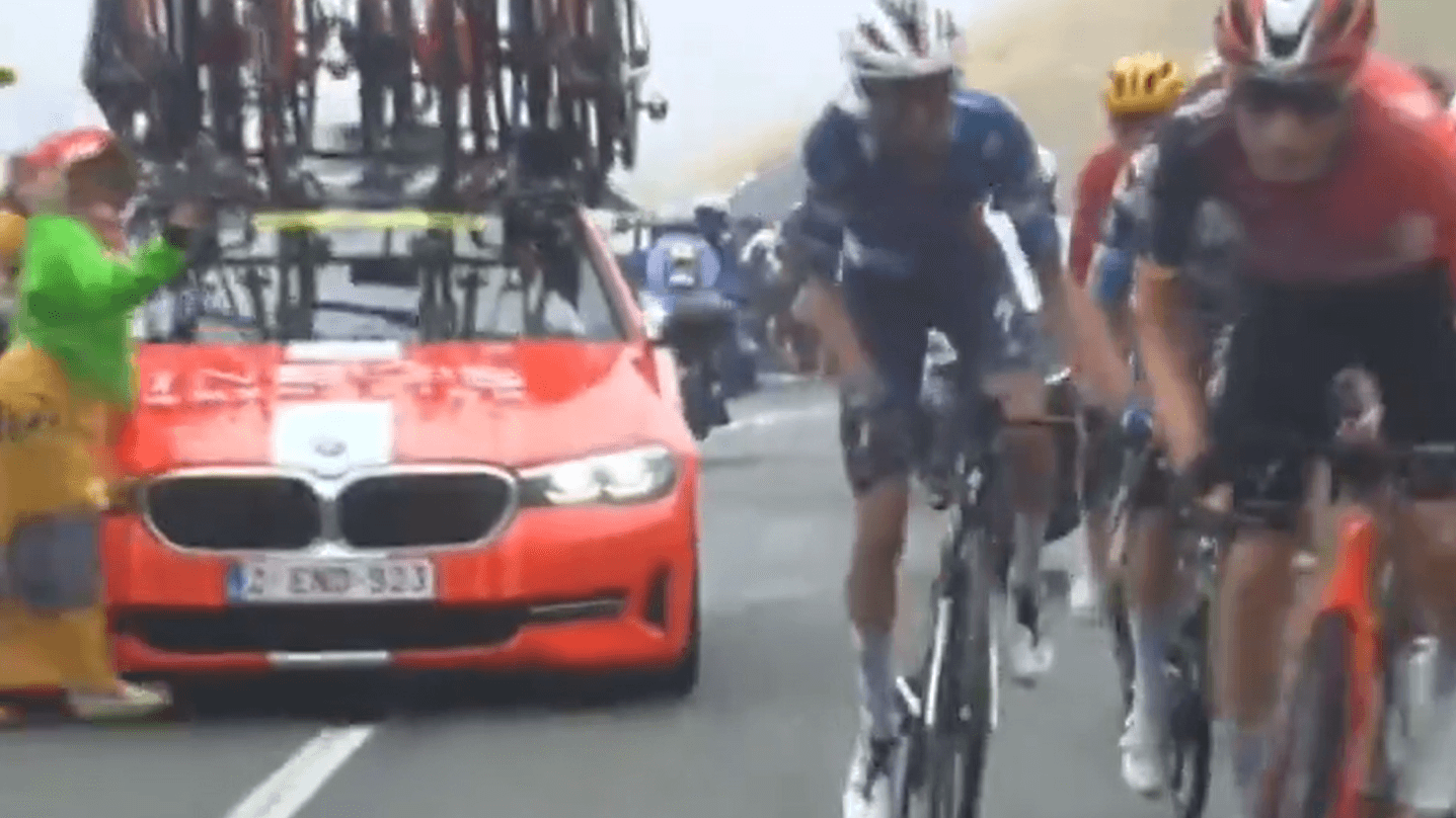 Verhängnisvoller Moment: Das rote Begleitfahrzeug vom Team Ineos (li.) fährt eine Person am Straßenrand an.