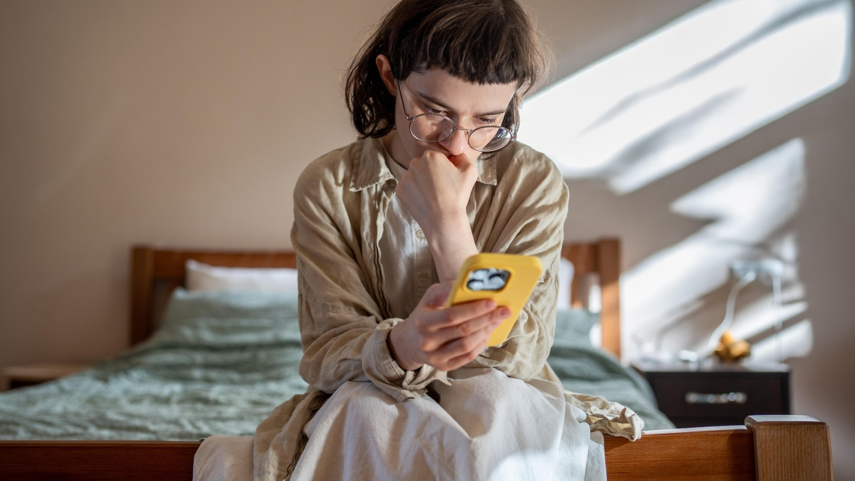 Eine junge Frau nutzt ihr Handy. E-Mental-Health kann therapeutische Begleitung jenseits der klassischen Praxisräume ermöglichen.