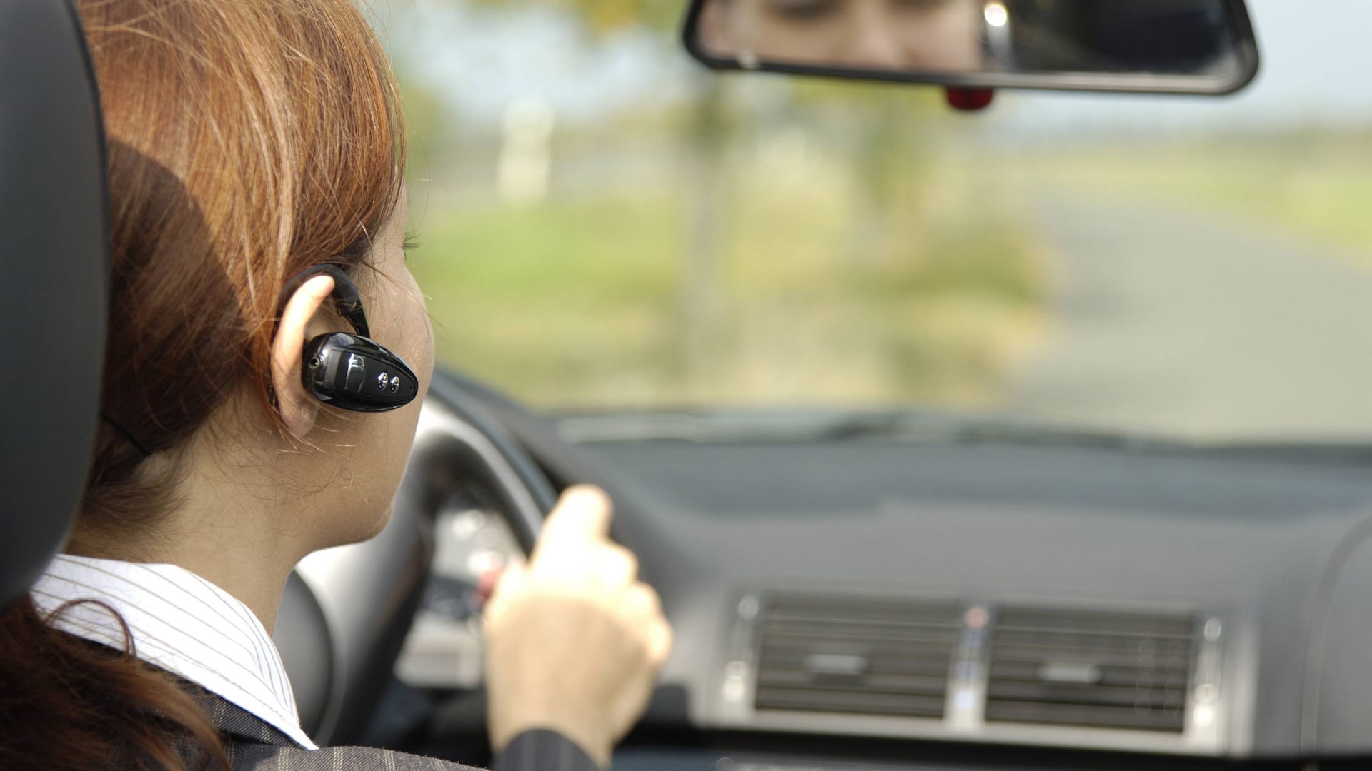 Bluetooth-Ohrhörer am Steuer: Bluetooth ermöglicht es Anwendern ohne Handy in der Hand zu telefonieren.