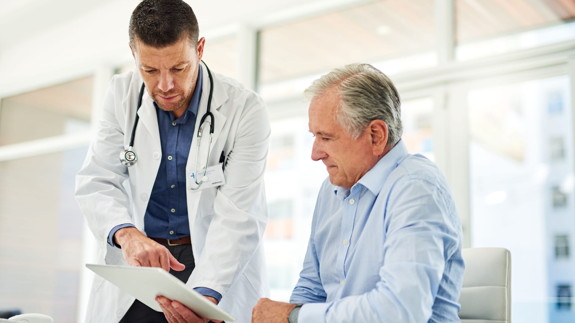 Ein Arzt erklärt einem Patienten einen Laborbefund. Ein Arzt erklärt einem Patienten einen Laborbefund.