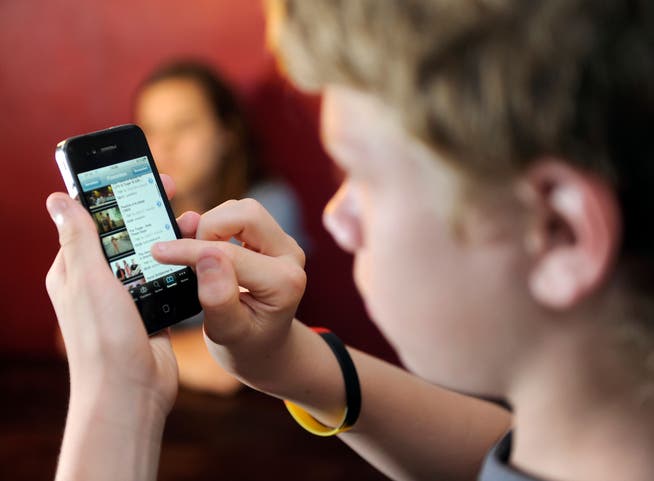 Was der da wohl schaut? Ein Jugendlicher am Smartphone.