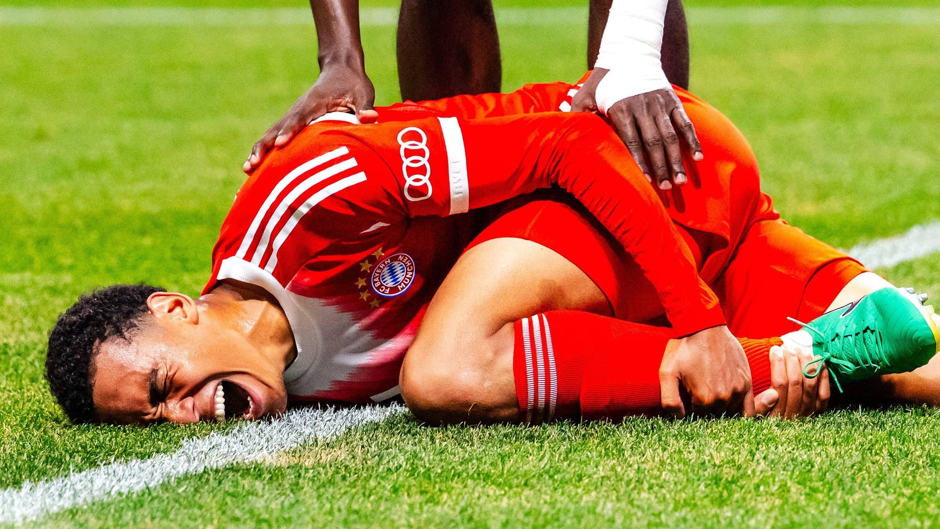 Jamal Musiala am Boden: Der Nationalspieler des FC Bayern verletzt sich am Bein. Jamal Musiala am Boden: Der Nationalspieler des FC Bayern verletzt sich am Bein.