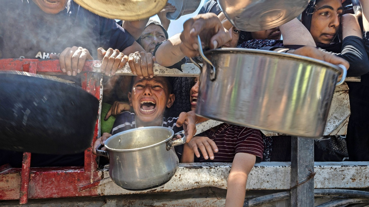 Gaza-Stadt, am 23. Juli: Palästinensische Familien hoffen an der Verteilstelle einer Wohltätigkeitsorganisation verzweifelt auf Lebensmittel.