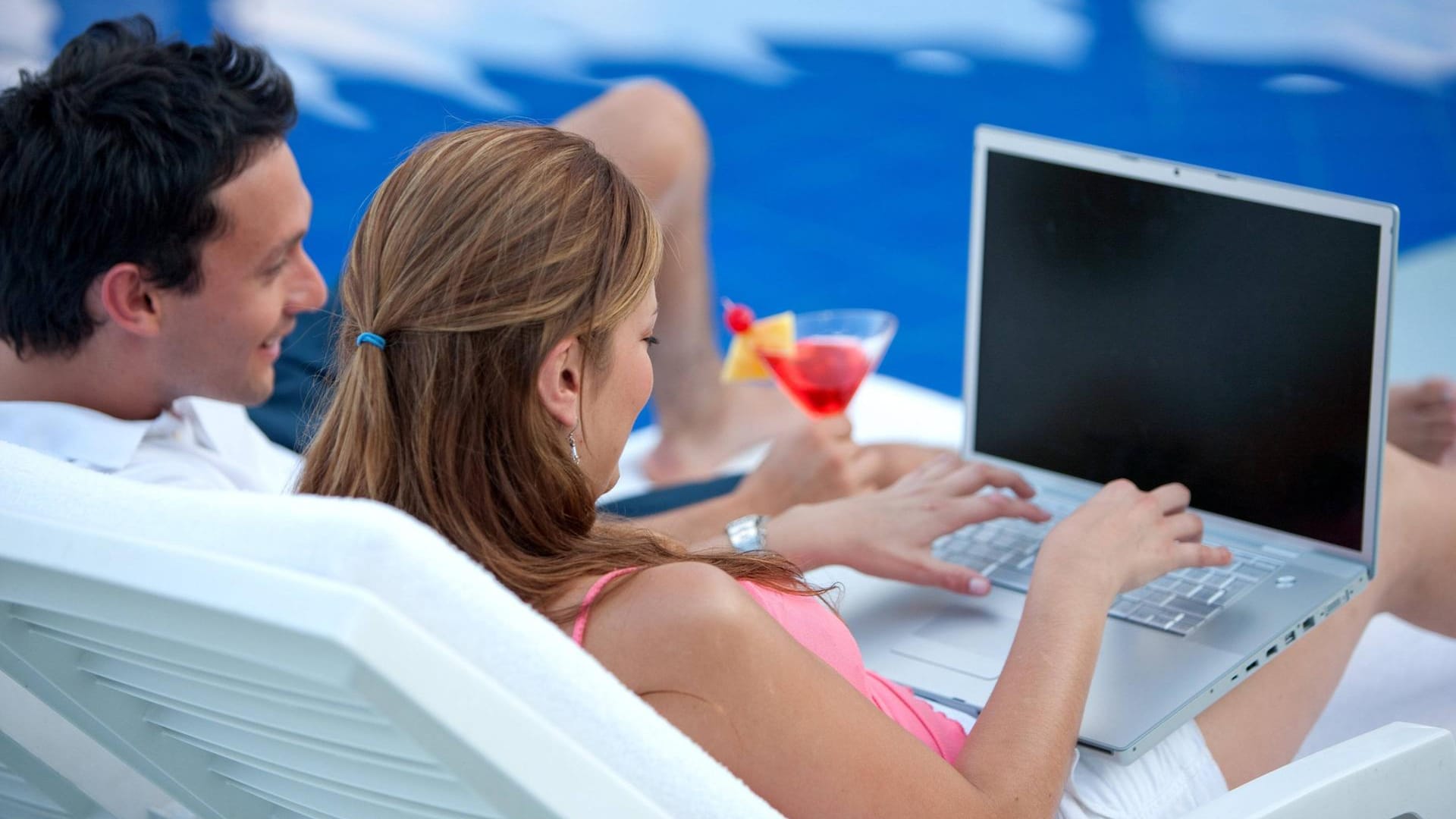 Frau mit Laptop am Pool: Bei der Nutzung des Hotel-WLANs sollte man einige Regeln beachten Frau mit Laptop am Pool: Bei der Nutzung des Hotel-WLANs sollte man einige Regeln beachten
