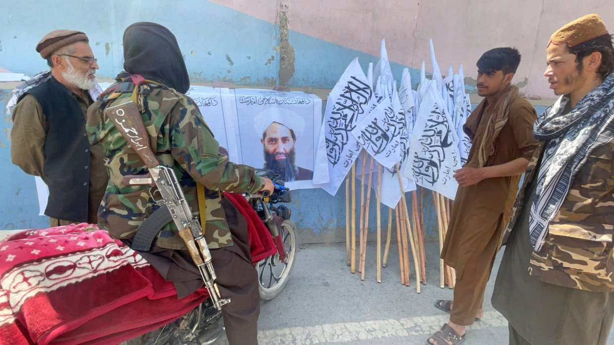 Taliban-Mitglieder stehen um ein Bild ihres Anführers Haibatullah Akhundzada, 26.8.2021.