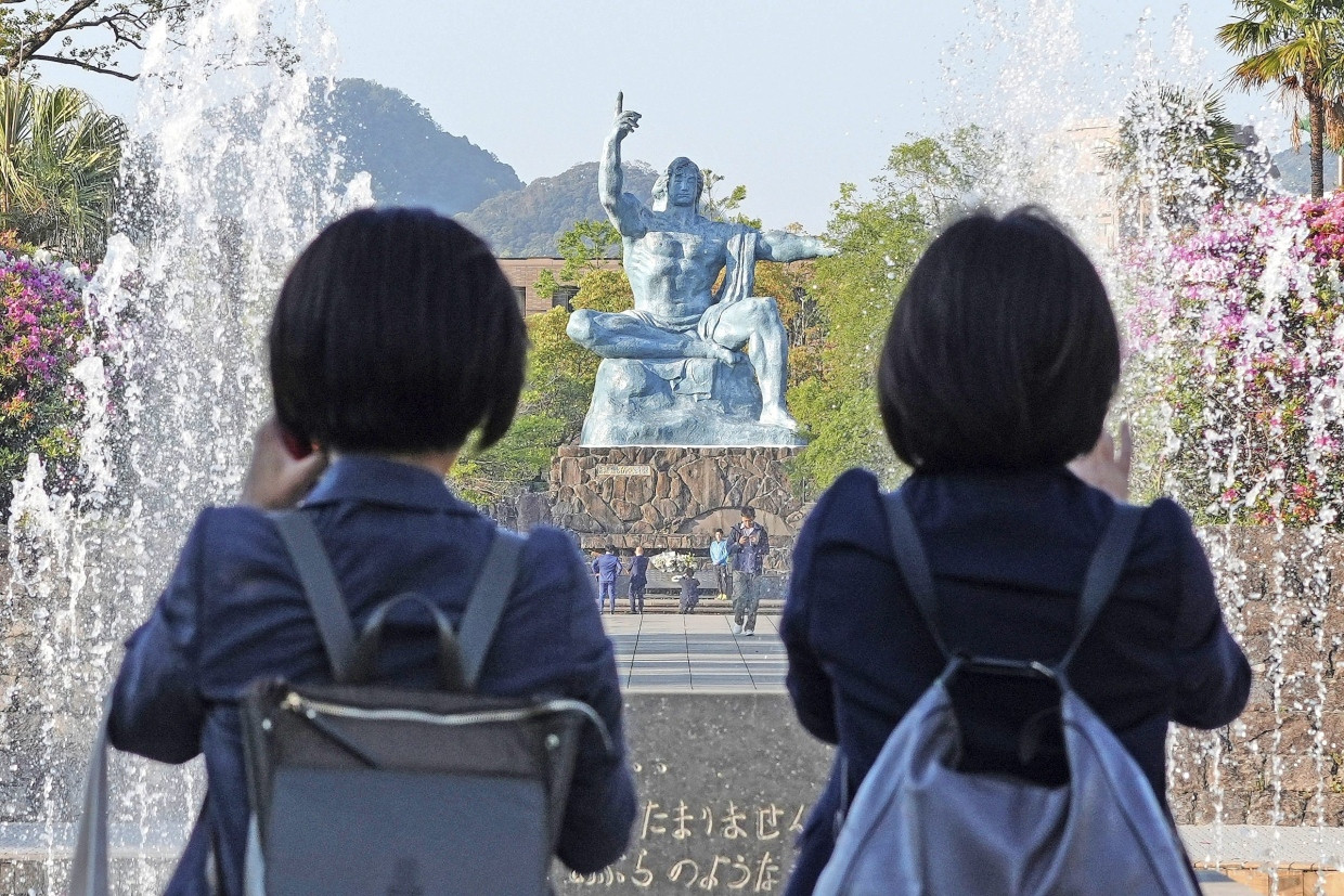 Besucher im April vor einer Skulptur im Friedenpark von Nagasaki