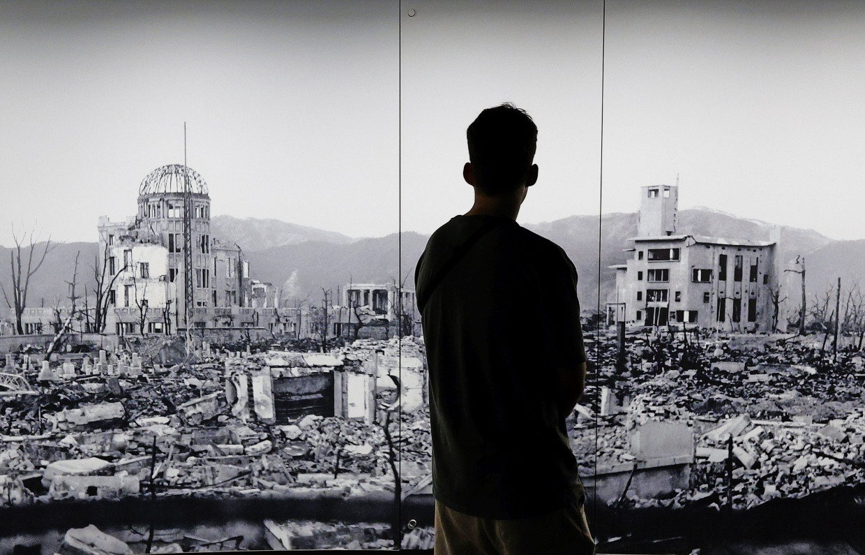 Ein Besucher des Peace Memorial Museum in Hiroshima steht vor einer großen Aufnahme der zerstörten Innenstadt