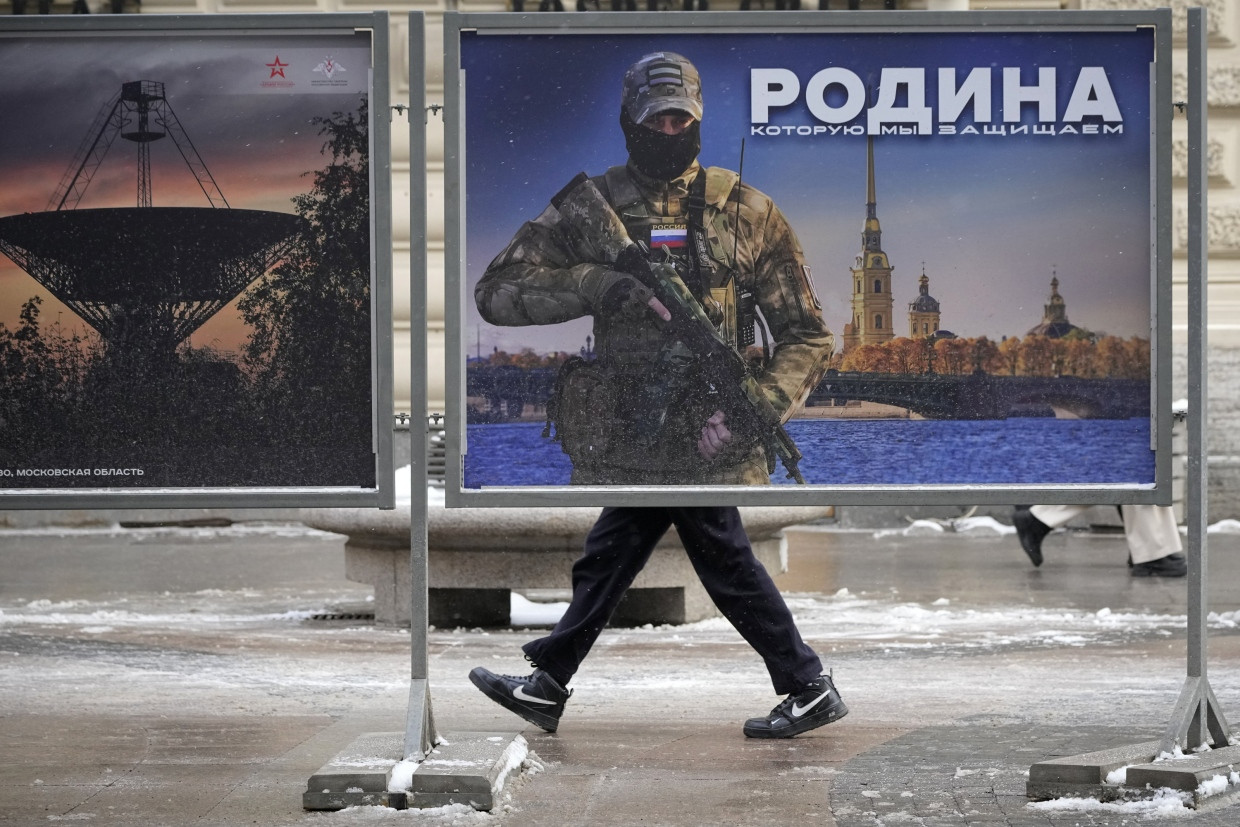 Ein Mann geht im Februar 2023 an einem Plakat mit dem Bild eines russischen Soldaten und der Aufschrift „Wir verteidigen das Vaterland“ vorbei.