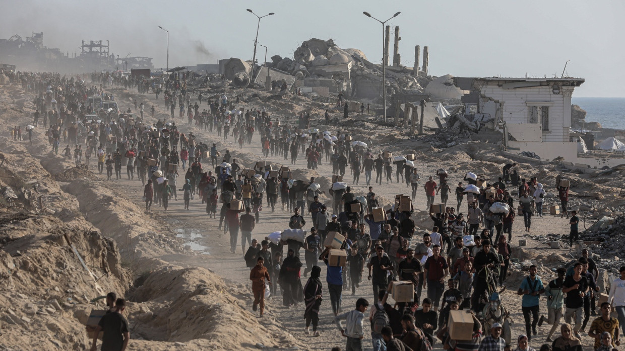 Langer Marsch nach der Verteilung: Flüchtlinge mit Hilfspaketen von einer GHF-Verteilung in Gaza-Stadt